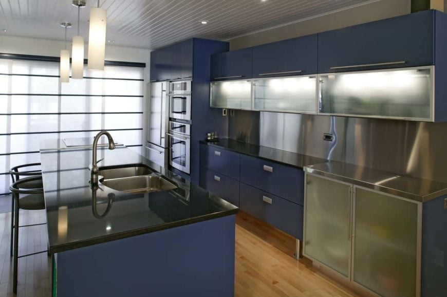 看看这个厨房，你可以马上看出它散发着一种专业的气息，就像它是由一位厨师拥有的一样。它有明亮的亚光蓝色橱柜，带有现代美感，和不锈钢元素和黑色台面完美搭配。