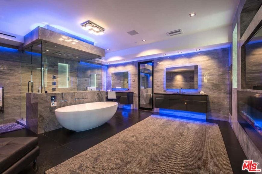 定制的主浴室拥有黑色瓷砖地板和棕色地毯。房间里的蓝色灯光十分引人注目。该房间提供了两个浮动梳妆台和一个步入式淋浴房，以及一个独立浴缸。