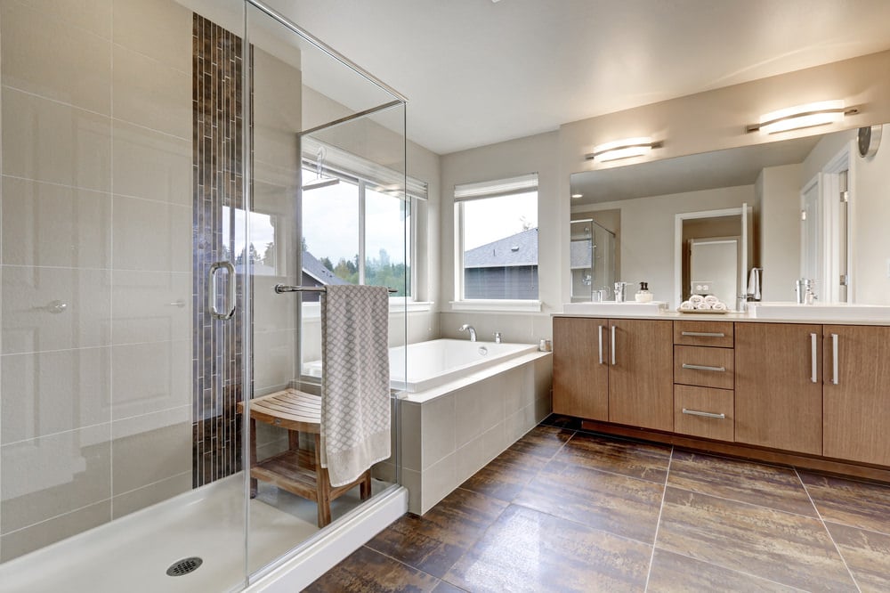 宽敞的主浴室设有瓷砖地板和米色墙壁。该房间提供了一个带有双水槽的洗涤台，一个落地式浴缸和一个步入式淋浴区。