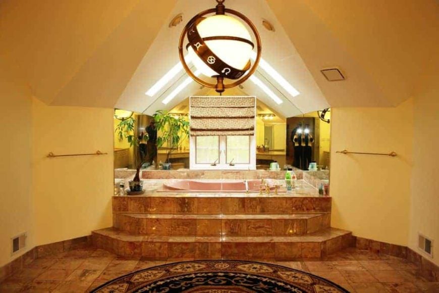 专注于这个兼收并蓄风格的主浴室的华丽的插入式深浸泡浴缸，由时尚的吸顶灯照亮。