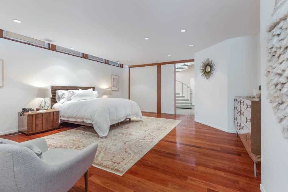 宽敞的主卧室以白色墙壁和白色天花板为特色，由嵌入式灯照明。这间房间以前属于乔治·哈里森(George Harrisons)的儿子达尼(Dhani)，里面有一张舒适的床，两侧都有台灯照明