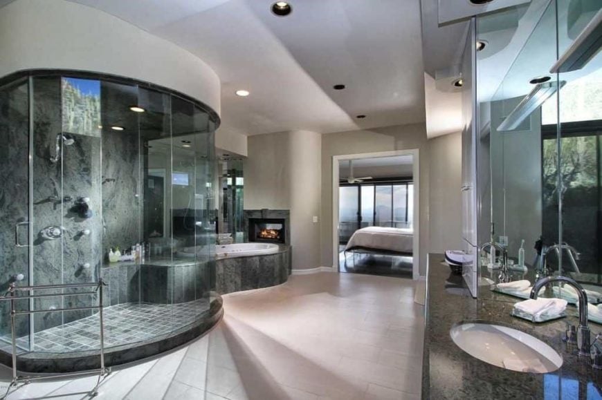 现代主浴室拥有一个时尚的步入式淋浴房，旁边有一个带壁炉的浸入式浴缸。水槽柜台设有花岗岩台面以及。