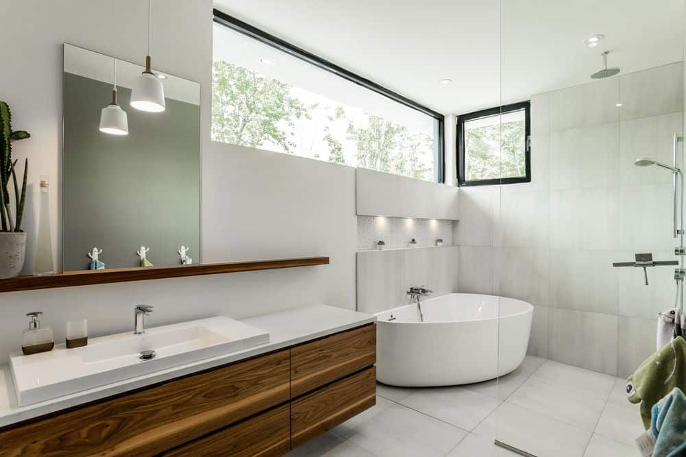 现代化的主浴室，有一个宽大的浮动洗手池和一个角落的独立式浴缸，靠近淋浴区。