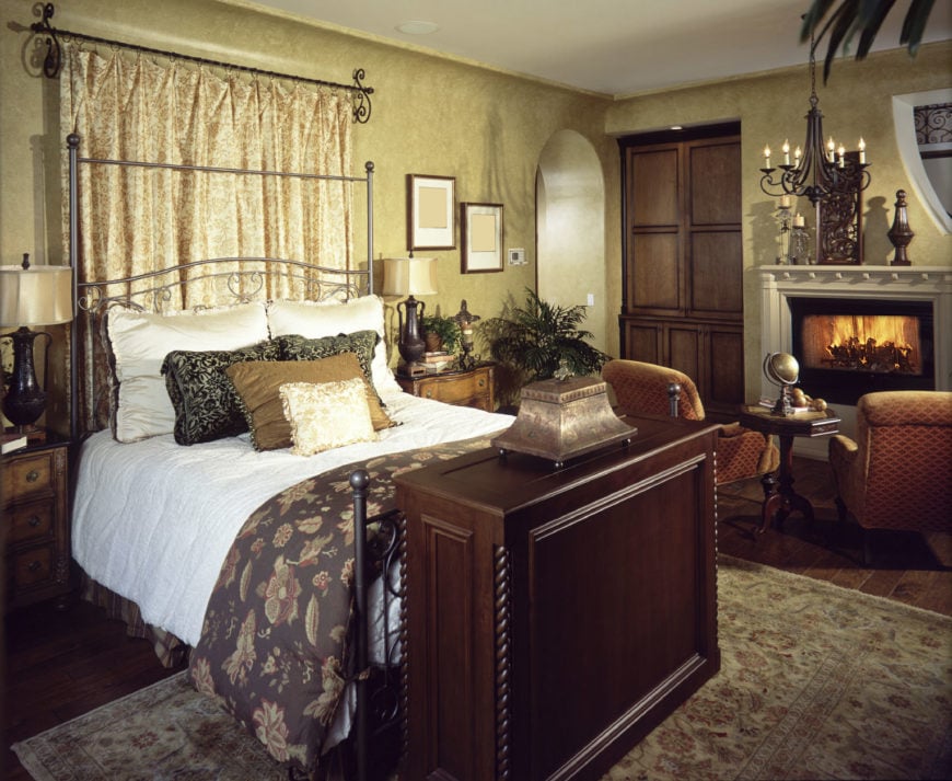 这主卧室之间提供了一个华丽的金属床上木质床头柜和客厅的壁炉铁艺吊灯照亮。它有一个开放的拱门和宽木板地板,一个典型的小地毯。
