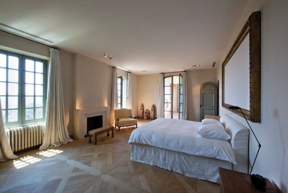 在法国里维埃拉的巴勃罗·毕加索家中，主卧室配有一张舒适的床和一把扶手椅