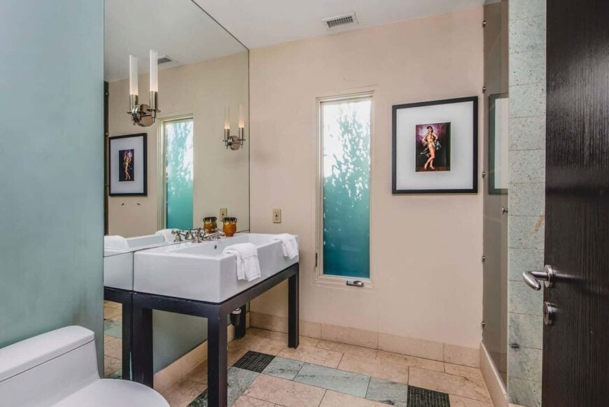 客房的浴室设有一个大水槽，前面有一面大镜子，由优雅的壁灯照明。图片来自Toptenrealestatedeals.com。
