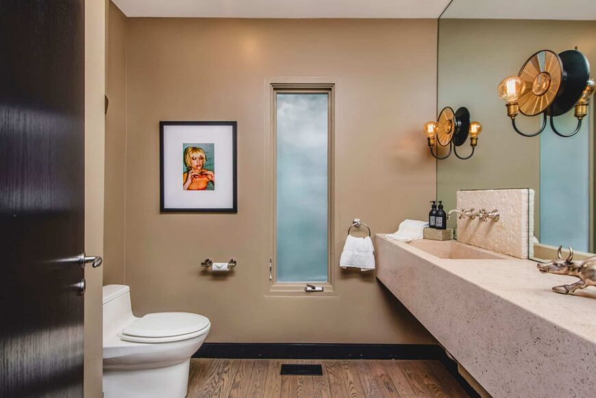 厕所区采用硬木地板和米黄色墙壁。该房间还设有一个带单水槽的浮动梳妆台。图片来自Toptenrealestatedeals.com。