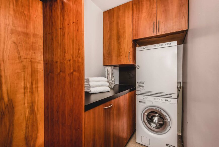 洗衣区设有木制橱柜和抽屉，以及一个黑色的柜台。图片来自Toptenrealestatedeals.com。