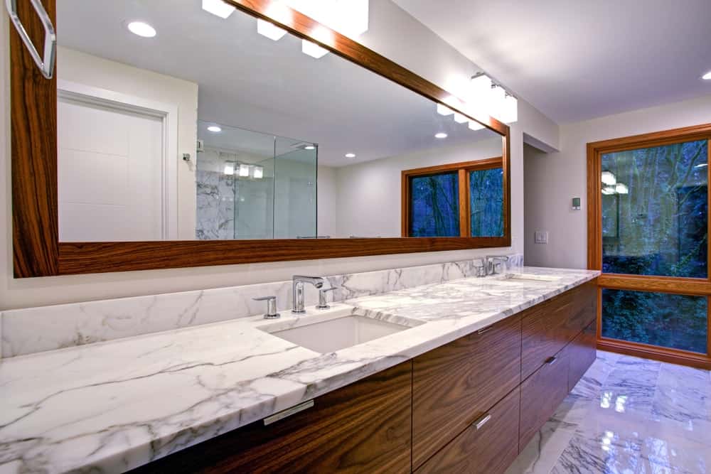 时尚的现代浴室设有双洗手池梳妆台和大理石台面。