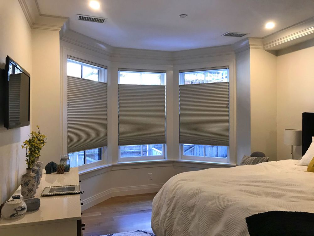 这间卧室设有一张舒适的大床和墙上的宽屏电视。窗户还设有窗帘。天花板上有凹进去的顶灯。