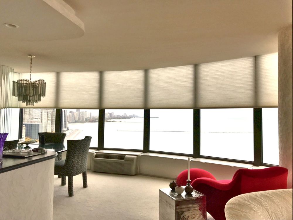 一个大房间，配有一套优雅的家具，铺着地毯的地板，定制的天花板和玻璃窗上的窗帘。