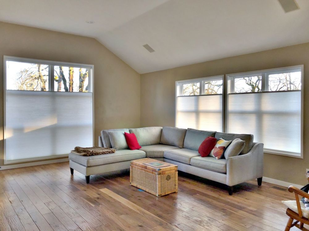 生活空间设有硬木地板和棕色墙壁，以及带遮阳帘的玻璃窗。房间还提供一个现代化的l型沙发。