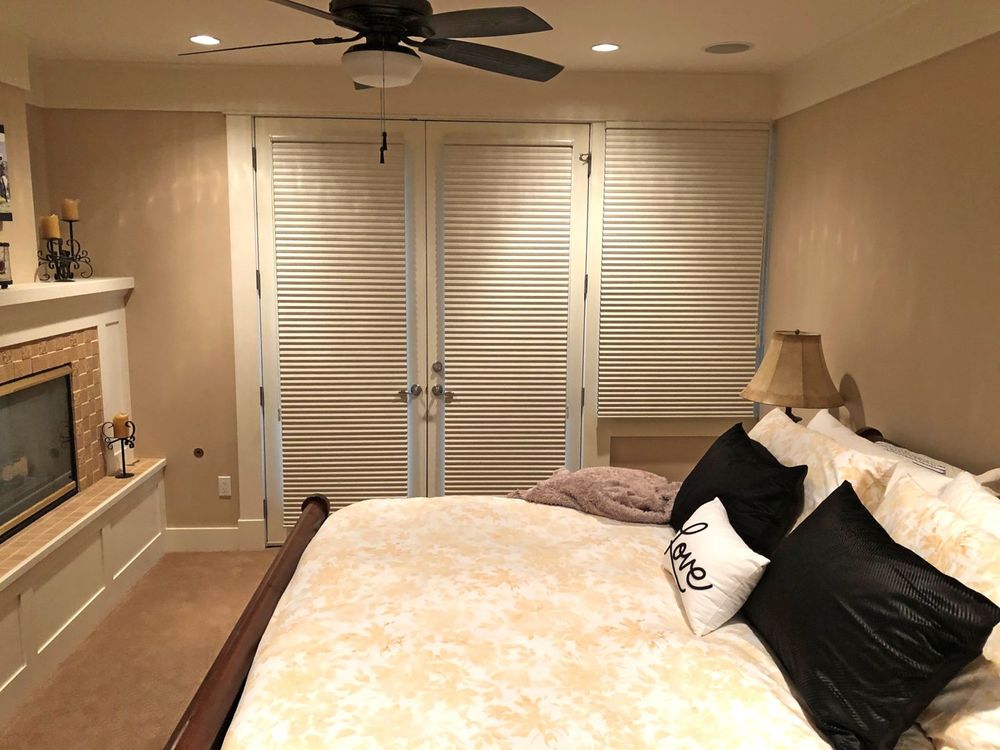 这间客房提供一个大而舒适的床，两边都有台灯。还有一个壁炉。这个房间还有棕色的墙壁和地毯地板。