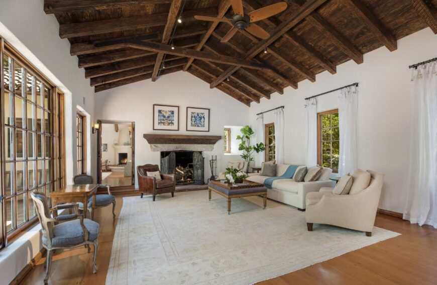 这栋房屋的正式客厅设有一组优雅的座椅和一座壁炉。房间以硬木地板为特色，上面铺着一块区域地毯。图片来自Toptenrealestatedeals.com。