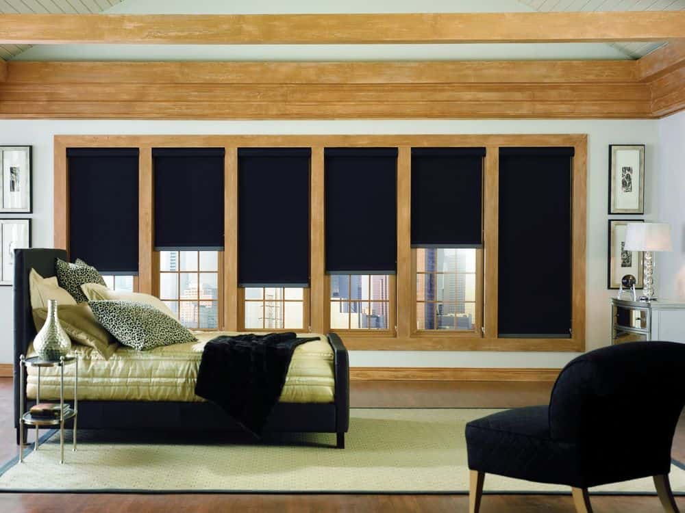 主套房拥有优雅的黑色床套装，搭配黑色椅子和黑色窗帘。房间里铺着硬木地板，天花板上有横梁。