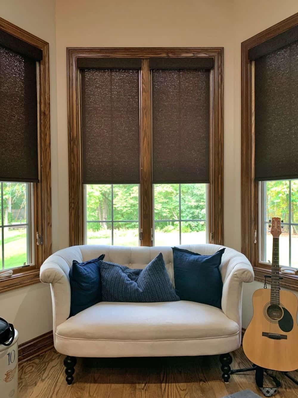 专注地看这个家的沙发，以木框和窗帘为特色的窗户。