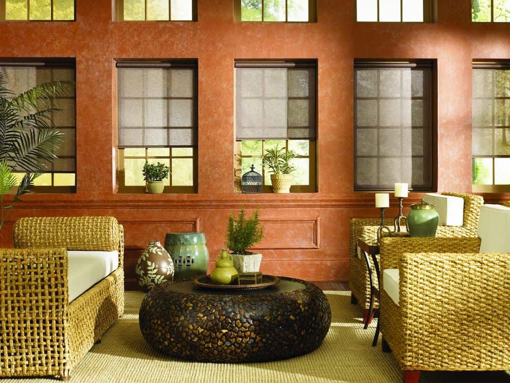 客厅设有一组迷人的座椅和一个时尚的中央桌子。这座房子拥有华丽的橙色墙壁和多扇窗户。