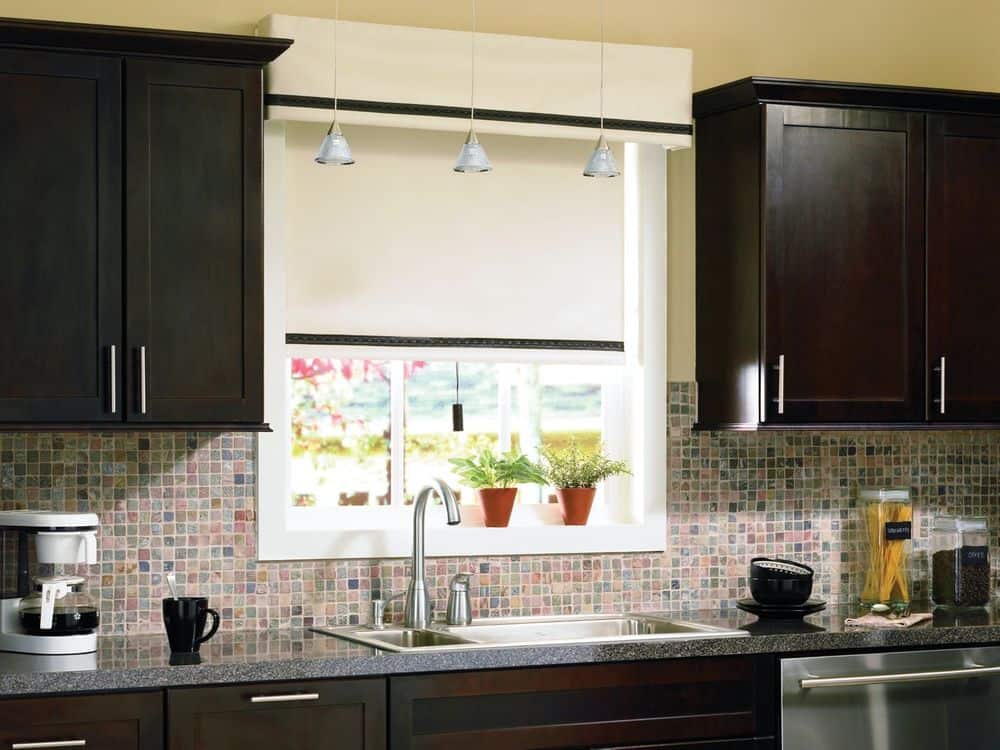 这间厨房设有橱柜和花岗岩顶部厨房柜台，以及瓷砖后挡板和米黄色的墙壁和天花板。