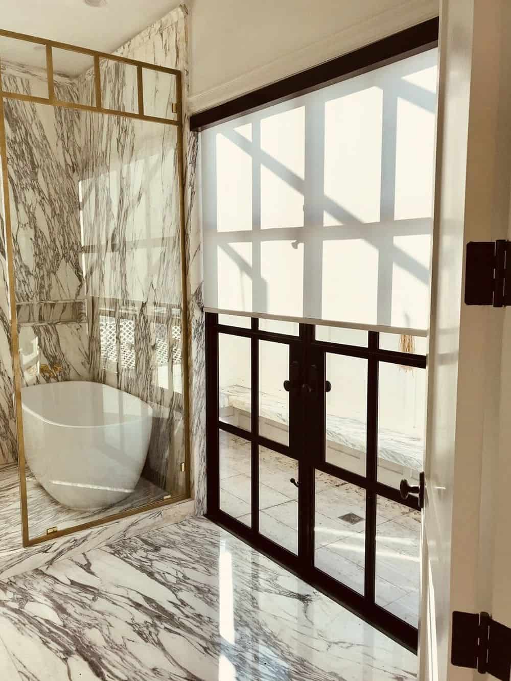 这间主浴室拥有豪华的大理石瓷砖地板和墙壁。它还提供一个独立的浴缸。房间的窗户以窗帘为特色。
