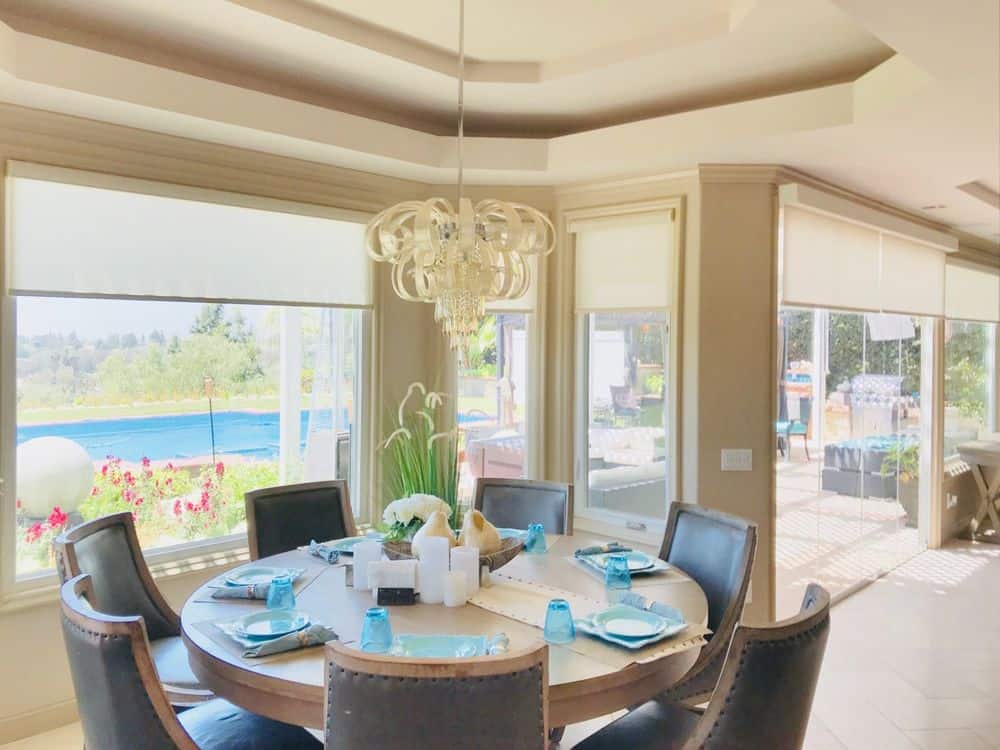 用餐区拥有一个优雅的圆形餐桌，由悬挂在托盘天花板上的豪华吊灯照明。窗户提供了室外区域的视野。