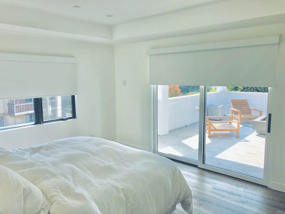 这间客房以白色墙壁、硬木地板和白色托盘天花板为特色。它提供了一个可爱的白色床组和窗户和门有卷帘。