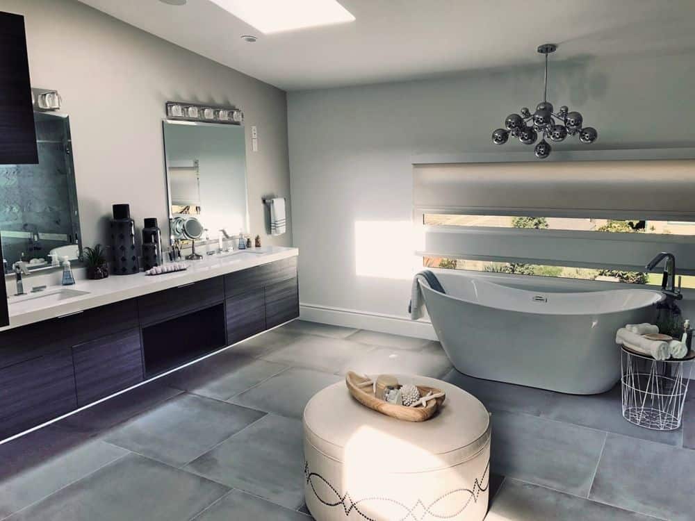 大型主浴室拥有一个独立的浴缸，由现代吊灯照明，以及一个带有两个水槽和一个化妆台的浮动梳妆台。该房间还设有中型瓷砖地板和带天窗的天花板。