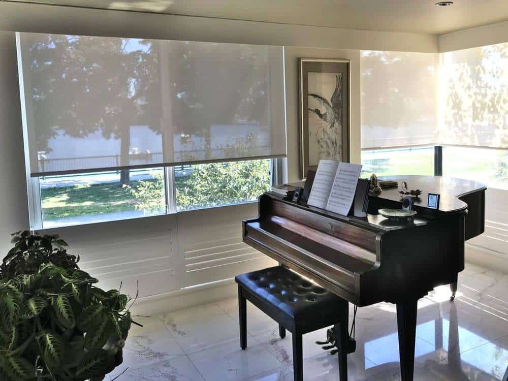 专注地看看这个家的一边，那里有古典的钢琴。该住宅以大理石瓷砖地板和带有遮阳板的玻璃窗为特色。