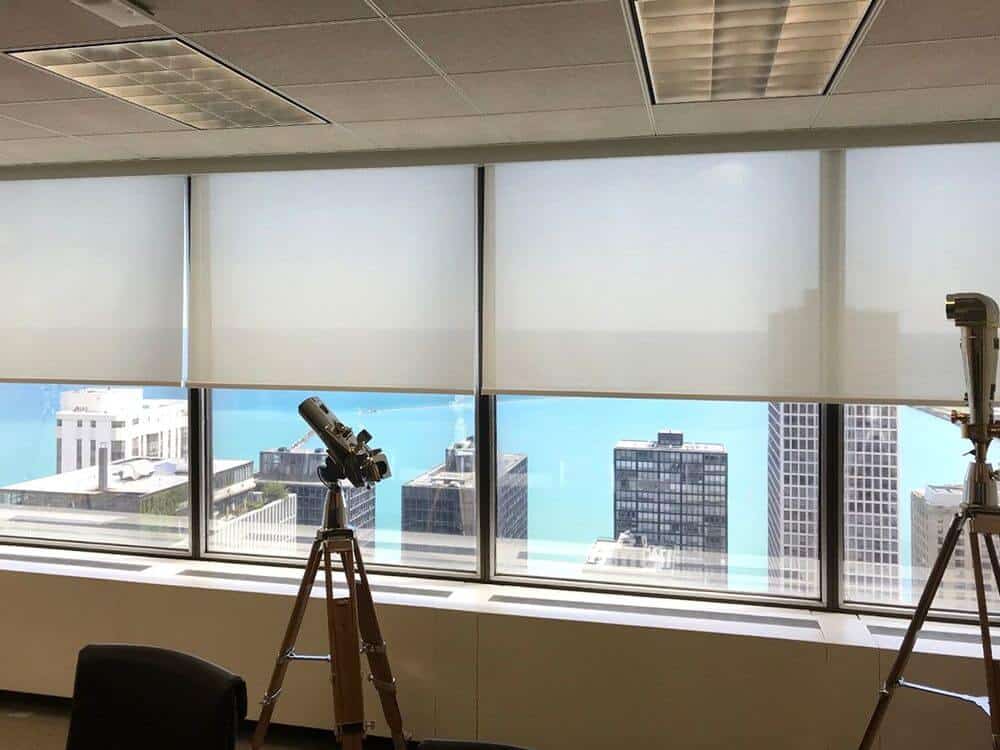 专注地看这个房间的现代玻璃窗，设有遮阳板。从这个房间可以俯瞰整个城市的美景。