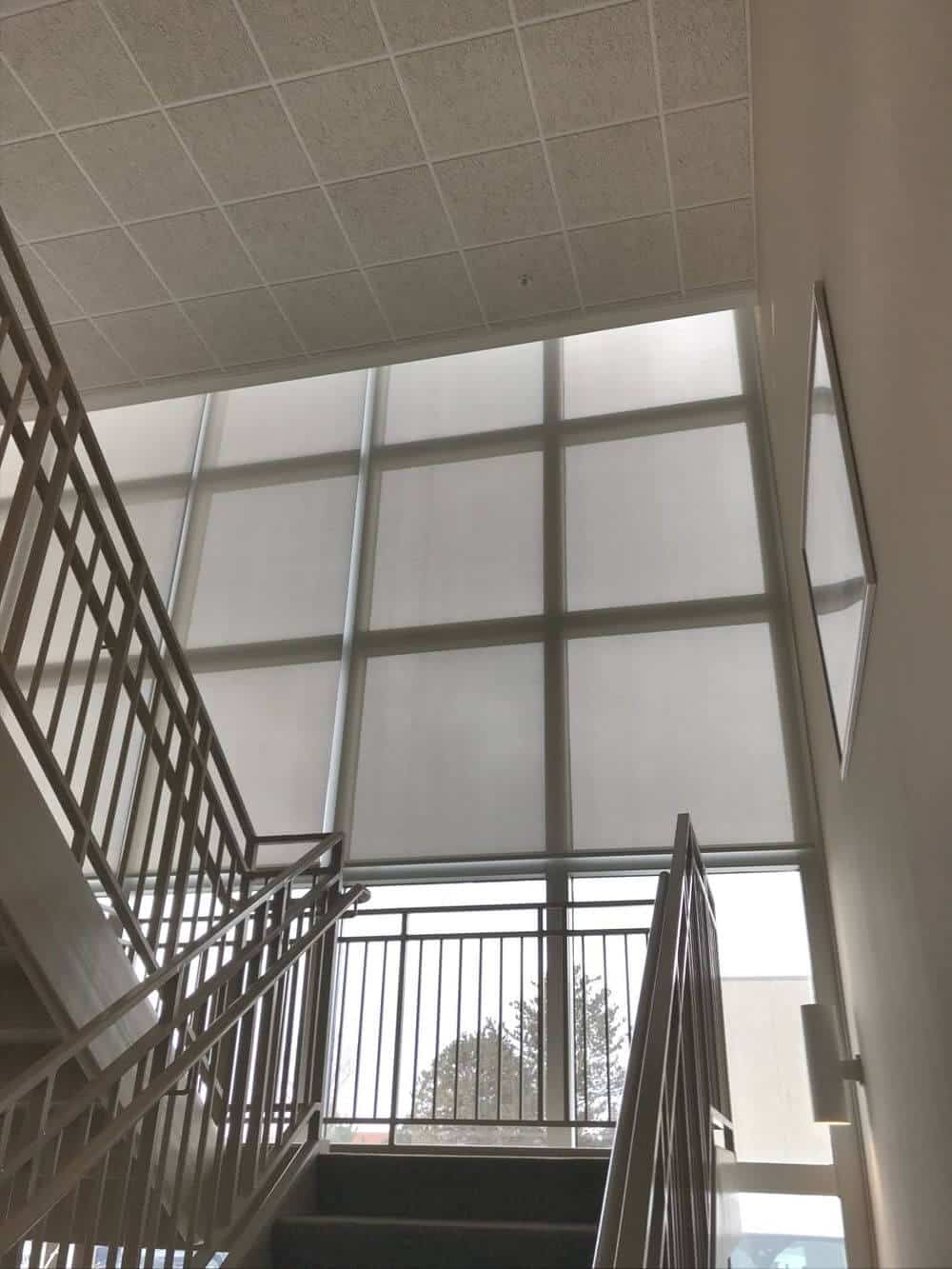 这栋房子的楼梯设置在带遮阳板的落地玻璃窗附近。这座房子还采用了很高的瓷砖天花板。