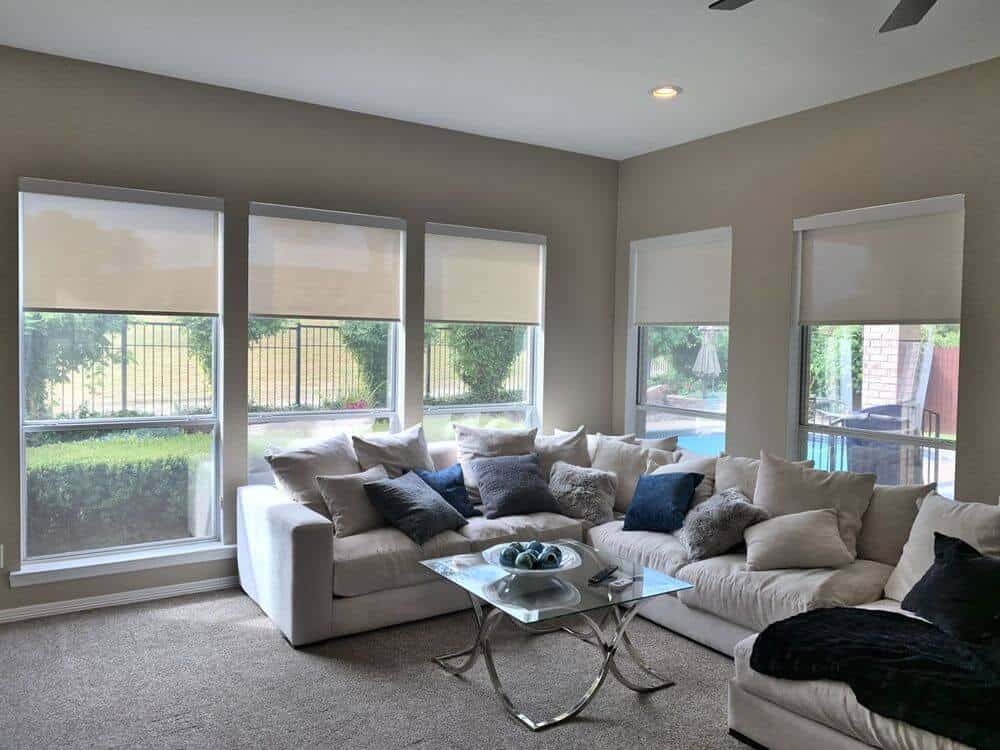 起居空间提供l型沙发套装，看起来绝对舒适。中间还有一张精致的玻璃桌。房间里铺着地毯，墙壁是灰色的，还有带遮阳板的玻璃窗。
