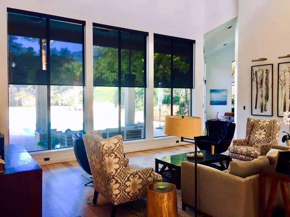 生活空间设有一组优雅的座椅和时尚的地毯覆盖抛光的地板。该区域有白色的墙壁和白色的高天花板，以及带有太阳能遮阳帘的垂直玻璃窗。