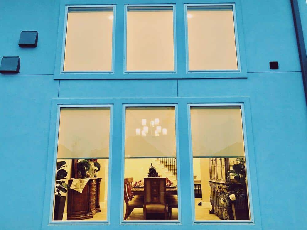 从房子外面可以看到这所房子的玻璃窗和遮阳板。房子外面漆成浅蓝色。