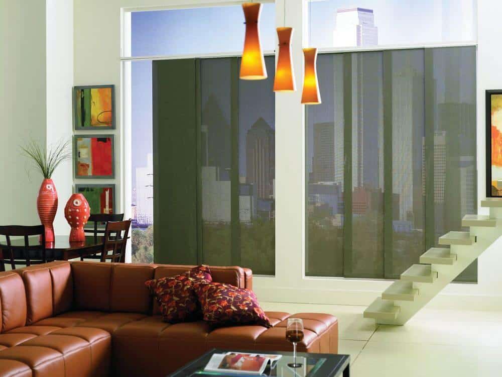 一个大房间设有一个起居空间，棕色优雅的皮沙发由吊灯照明。还有一套木制餐桌。该住宅设有带遮阳板的大玻璃窗。