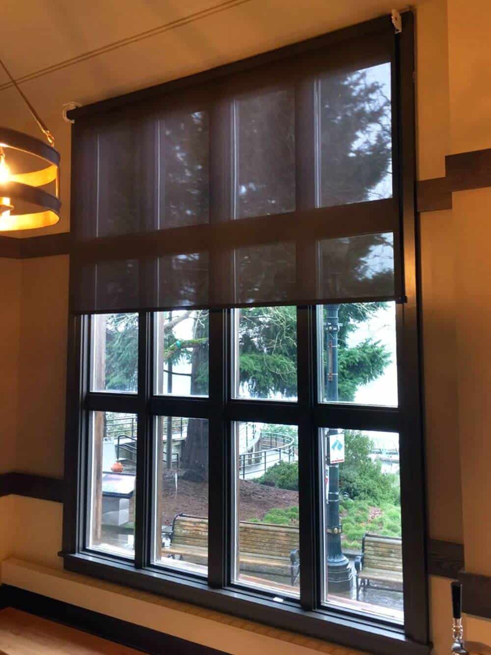 这所房子的窗户有华丽的窗框，并有太阳能窗帘。