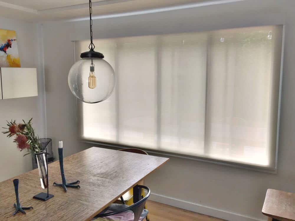 餐厅区设有浅灰色的墙壁和托盘天花板，以及硬木地板。房间提供了一个优雅的长方形餐桌，由吊灯照明。