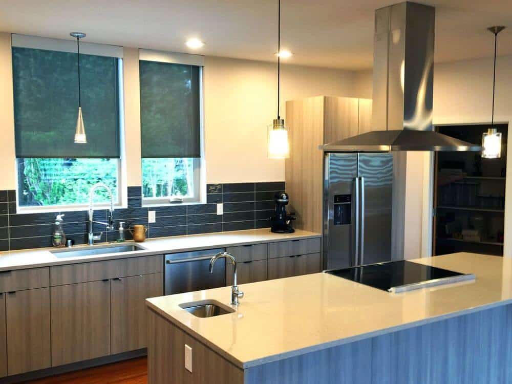 这个厨房有一个单墙厨房台面风格和一个由吊灯照亮的中心岛。这间房间有米黄色的墙壁和普通的天花板，还有硬木地板。
