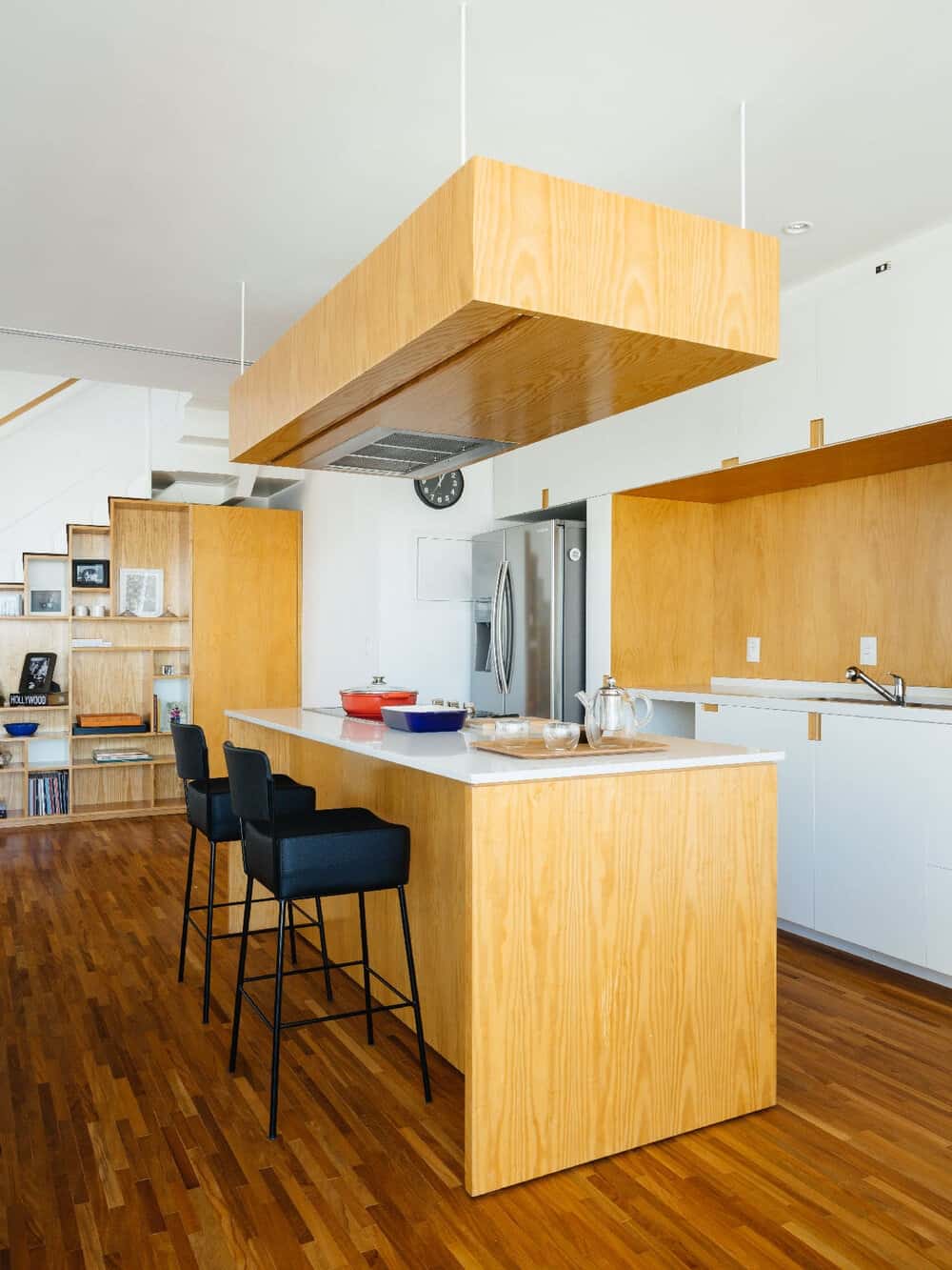 这是厨房区域的近距离观察，有一个大的厨房岛台，与深色硬木地板相比，它有更浅的木质色调，使其脱颖而出。这与后挡板搭配得很好。