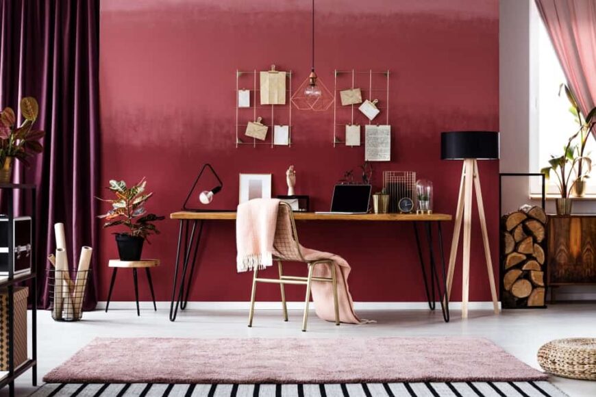 一个迷人的家庭办公室，带舒适的感觉和红色的墙壁。