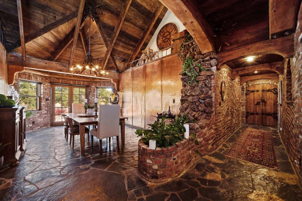 主楼层有一条美丽的走廊，通往正式的餐厅，那里也铺有宽大的石材地板，搭配高耸的拱形木质天花板。图片来自Toptenrealestatedeals.com。