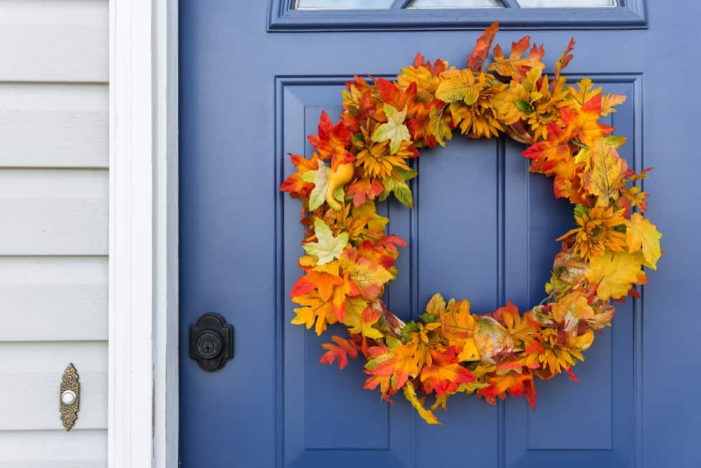 房子的蓝色木制前门点缀着秋叶编成的花环。