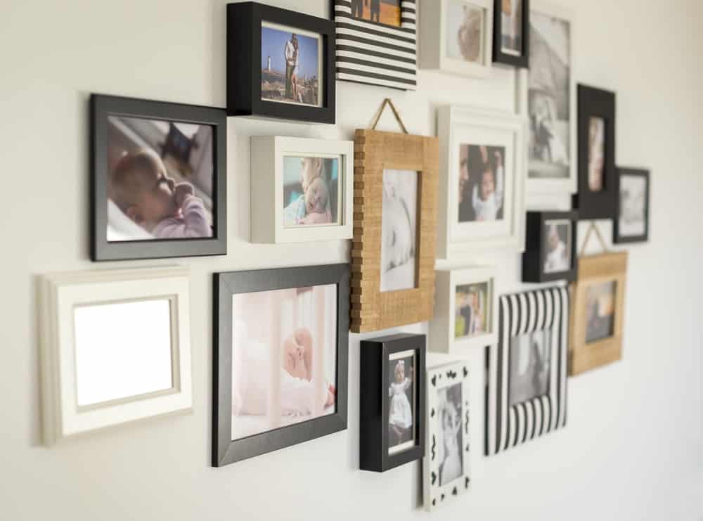 各种不同相框的个人照片挂在墙上，起到装饰效果。