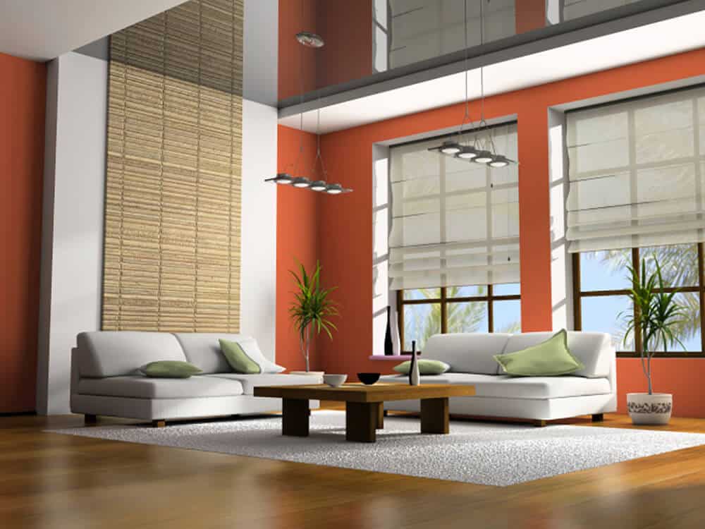 清新的客厅，橙色的墙壁，配套的灰色沙发和一个木制的咖啡桌，坐在大面积的地毯上。它有硬木地板和镜面天花板，天花板上装有工业挂件。