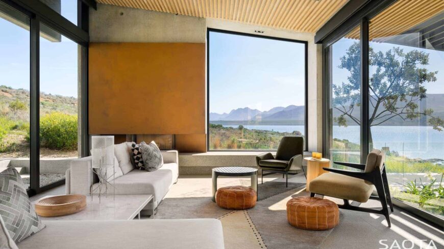 当代生活空间，玻璃窗俯瞰美丽的环境。座椅与墙壁和天花板一起看起来很美。