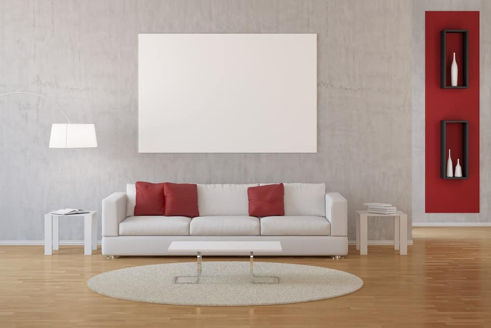一个简单的客厅，明亮的色调使墙壁和枕头的红色口音脱颖而出。