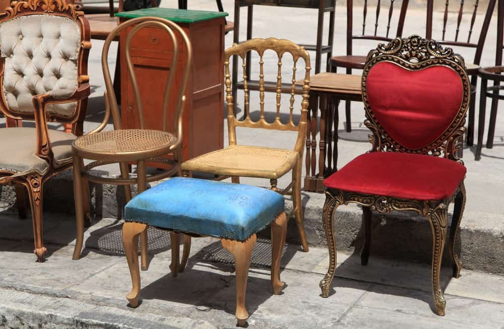 人行道上陈列的一套不同的椅子。