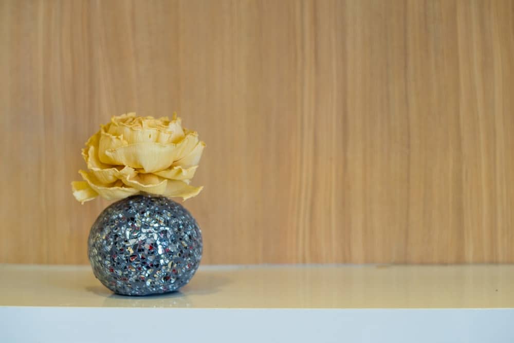 闪闪发光的花瓶里装饰的金纸玫瑰。