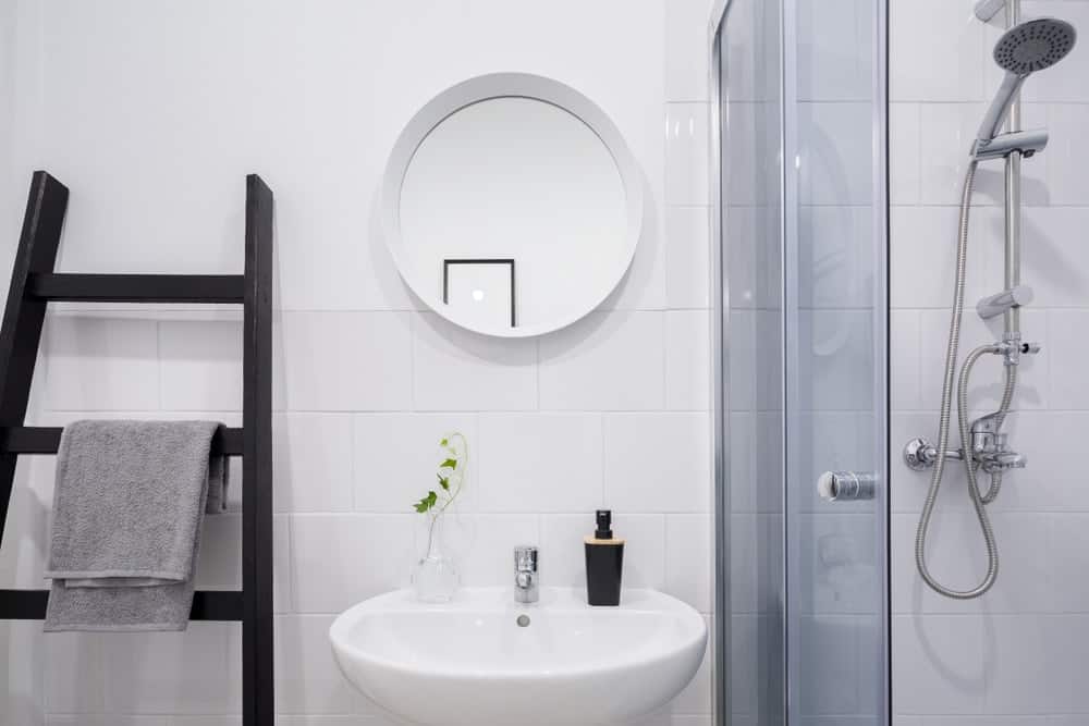 一个简单的浴室，辅以作为毛巾架的深色木梯。