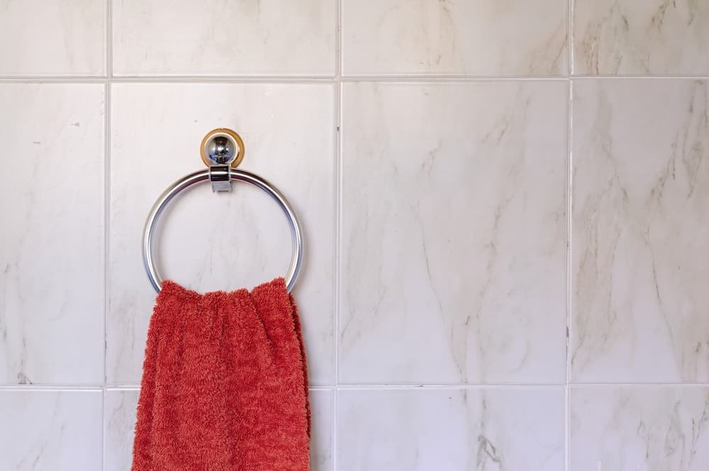 浴室墙上的壁挂式环形毛巾架特写。
