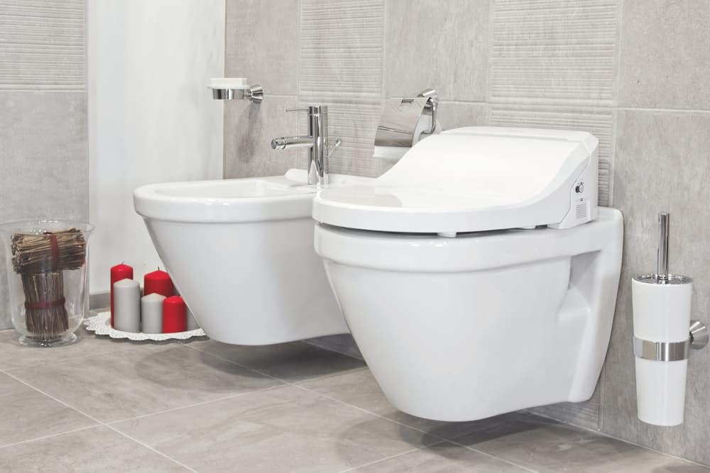 浴室里有一个现代化的浮动马桶，铺着灰色瓷砖。
