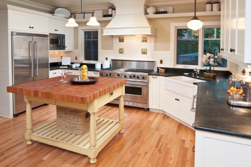 这间厨房以硬木地板和黑色台面上的木制厨房岛为特色。它也有不锈钢用具。